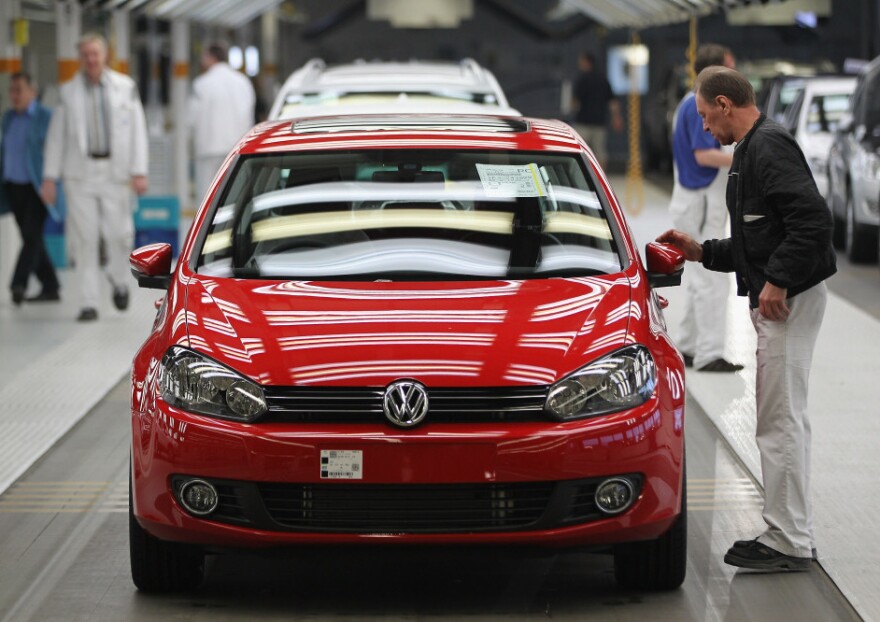 Workers prepare new Volkswagen Golf cars at a factory in Wolfsburg, Germany.