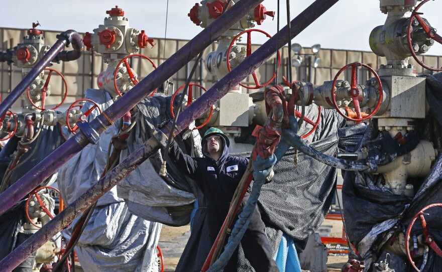 In this file photo from 2014, a worker adjusts pipes during a hydraulic fracturing operation near Mead, Colorado. The Trump administration is moving to roll back Obama-era rules aimed at reducing leaks of climate-changing methane from oil and gas plants.