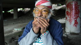 Jacobo Miguel Pinon Jr. plays the harmonica at his space in the Jungle, a homeless encampment that houses more than 400 people by some estimates.