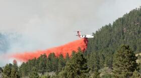 A heavy air tanker drops retardant on the July fire on Monday