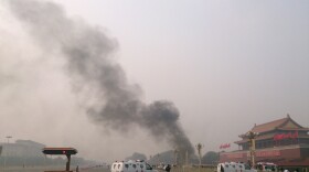 Police cars block off the roads leading into Tiananmen Square as smoke rises into the air after a vehicle crashed in front of Tiananmen Gate in Beijing on Oct. 28.