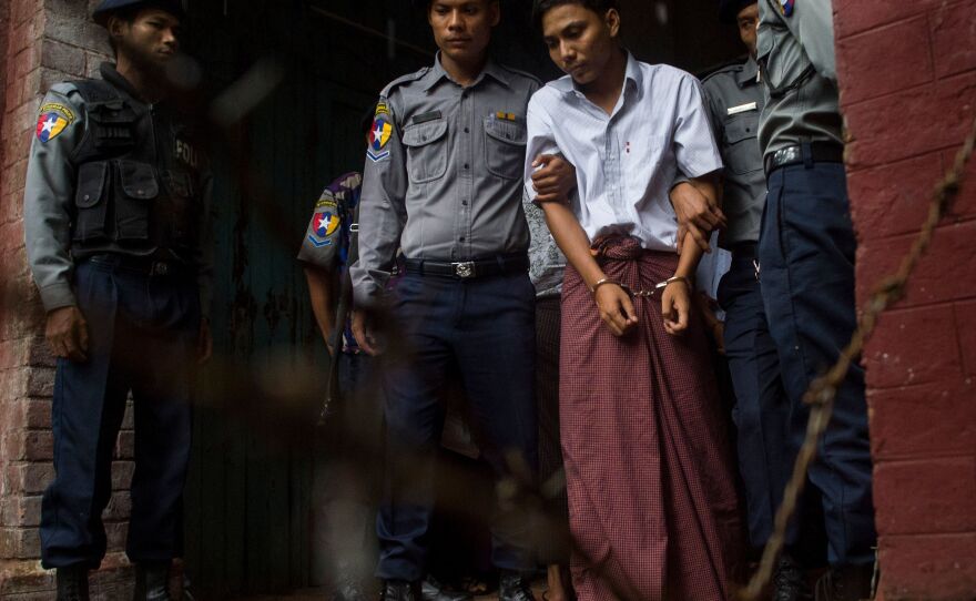 Kyaw Soe Oo, 28, leaves the Yangon courthouse in May, handcuffed and flanked by police officers.