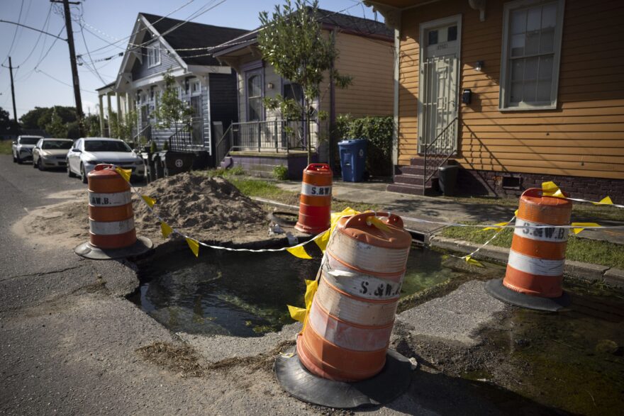 Sewerage and Water Board cones surround a hole welling up with water on Burgundy Street in the Holy Cross neighborhood of New Orleans on July 28, 2025.