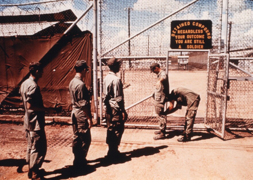 Guard searches prisoners at the gate to the pre-trial compound.