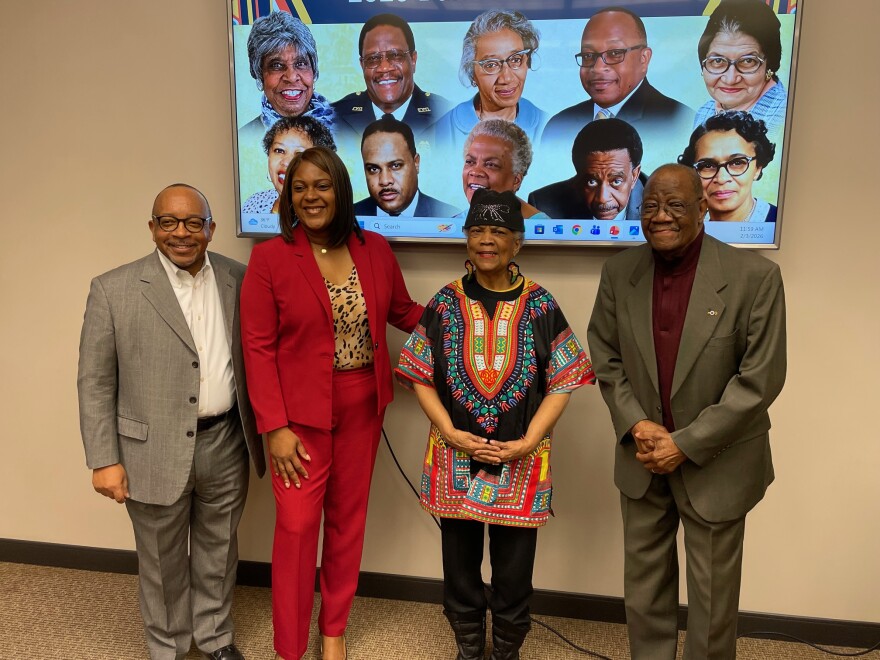 Evansville Mayor Stephanie Terry (2nd from left) poses with Black History Month Banner honorees (left to right) Rev. Adrian Brooks Sr., Sondra Matthews, and George Flowers Jr., standing in front of a screen depicting all the honorees, Feb 3rd, 2026