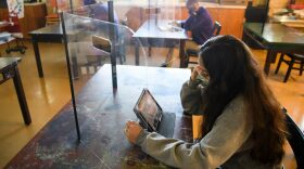 Students work behind protective barriers during an art class as they return to in-person learning at St. Anthony Catholic High School during the Covid-19 pandemic in Long Beach, California.