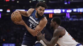 Minnesota Timberwolves center Karl-Anthony Towns (32) looks to drive around New York Knicks forward Julius Randle during the first half of an NBA basketball game, Monday, Jan. 1, 2024, in New York. (AP Photo/Adam Hunger)