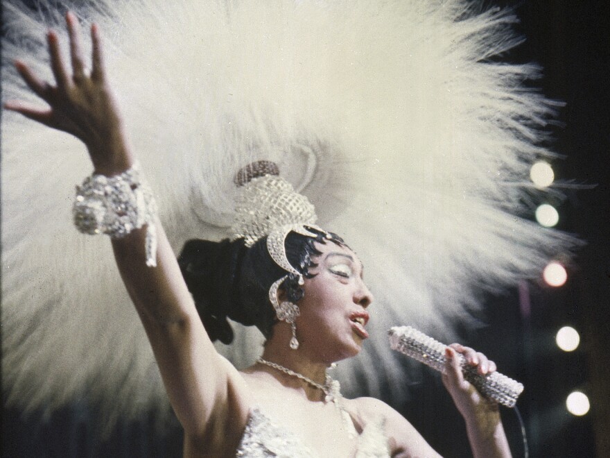 Josephine Baker holds a rhinestone-studded microphone as she performs during her show "Paris, mes Amours" at the Olympia Music Hall in Paris, France, on May 27, 1957.