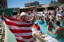 A fan cheers next to a pool at Circa Resort & Casino in Las Vegas while watching a live broadcast of a World Cup Group D soccer match between the United States and Australia, Friday, June 19, 2026. (AP Photo/John Locher)