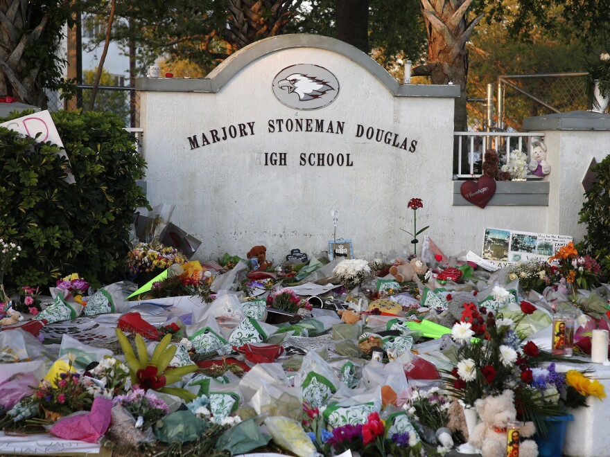 Flowers, candles and mementos sit outside one of the makeshift memorials at Marjory Stoneman Douglas High School in Parkland, Florida just days after the deadly shooting in 2018.