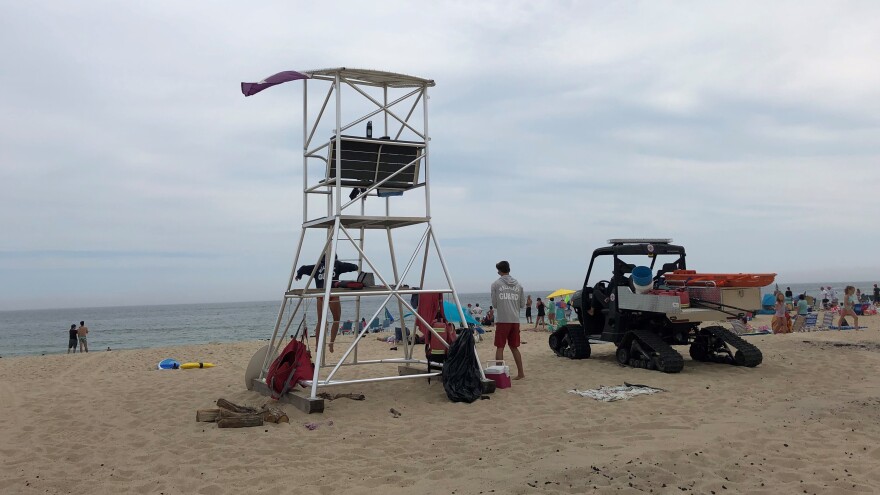 A taller lifeguard chair at Newcomb Hollow Beach is meant to help spot sharks and seals. Next to it, an all-terrain vehicle is equipped with a Stop the Bleed kit for shark bites.