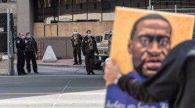 A demonstrator holds a portrait of George Floyd outside the Hennepin County Government Center in Minneapolis, Minnesota. The high-profile trial of former officer Derek Chauvin began on March 29. (Kerem Yucel/AFP/Getty Images)