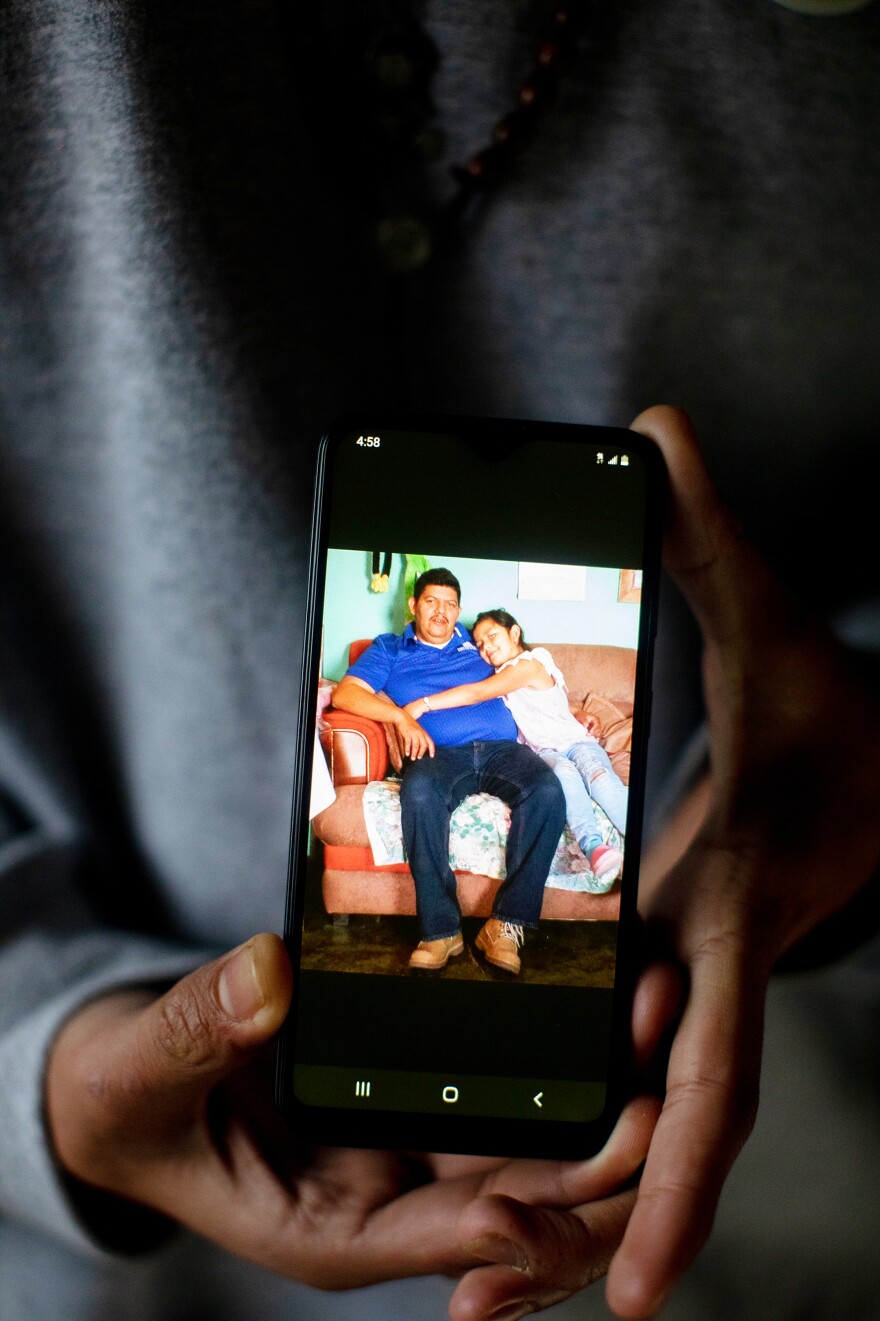 Marvin holds his cell phone with a photograph of his father and younger sister. He currently lives with his sponsor, his uncle, and attends high school while he waits for his immigration court date.