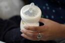 A woman holds a bottle of baby formula as she feeds her infant son in San Antonio on May 13, 2022. (Eric Gay/AP)
