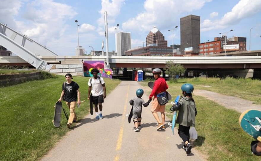 Helen Barrett Montgomery School No. 50 student Rahmatullah walks hand and hand with Skateistan instructor Farzad Sharafi during the groups first trip to the ROC City Skatepark.