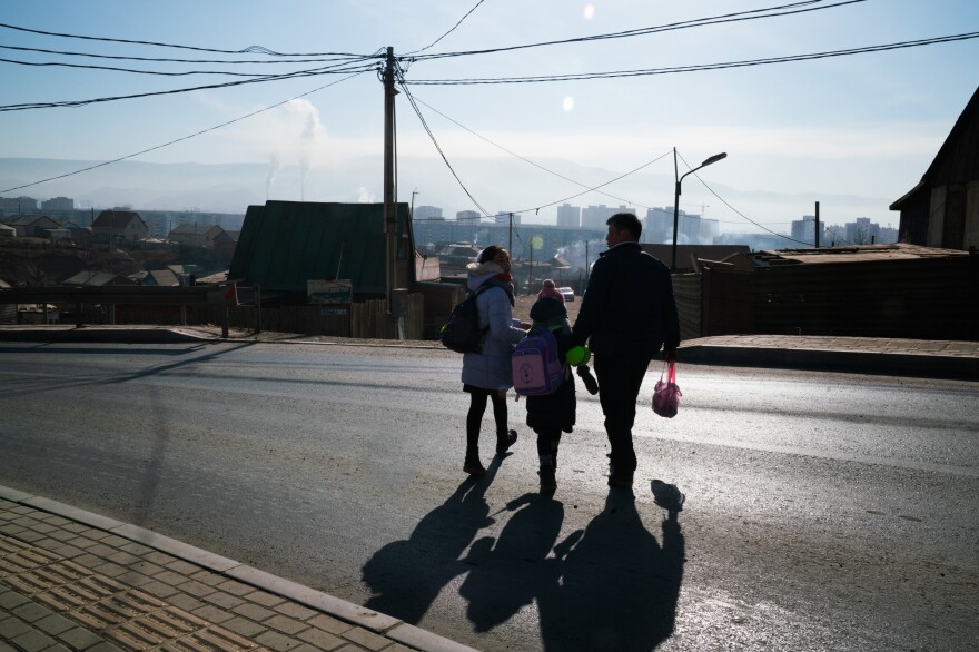 Oyutan lives with his family in Ulaanbaatar's <em>ger</em> district, an unplanned area on the capital city's outskirts where low-income migrants have settled. He escorts two of his daughters to school, wary of distracted drivers.