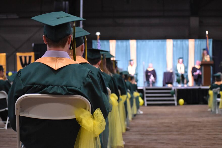 Whitefish High School graduates sit in evenly spaced chairs at the Majestic Valley Arena near Whitefish June 6, 2020 as classmates and faculty gave speeches and family look on from the bleachers.