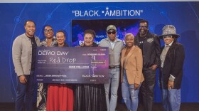 A group of people of hold a check and pose for a photo