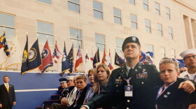 A group of military members and their families are sitting while attending a ceremony.