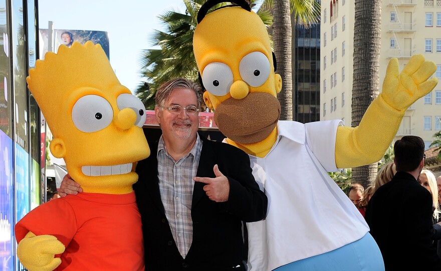 <em>The Simpsons</em> creator and cartoonist Matt Groening stands with Bart and Homer Simpson when they were honored with a star on the Hollywood Walk of Fame in 2012.
