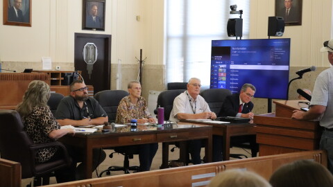 (From left to right) Grady County Commissioners Zachary Davis, Ruth Bingham and Gary Bray sit next to Grady County District Attorney Jason Hicks at a meeting on September 8.