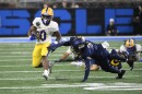 Pittsburgh running back Desmond Reid, left, runs with the ball past the reach of Toledo safety Jaden Dottin, front right, during the first half of the GameAbove Sports Bowl NCAA college football game, Thursday, Dec. 26, 2024, in Detroit.