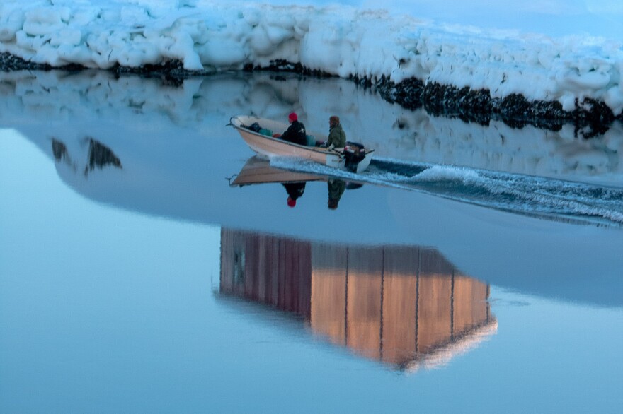 Hunters head out to sea in a motorboat in Tiniteqilaaq, Greenland.