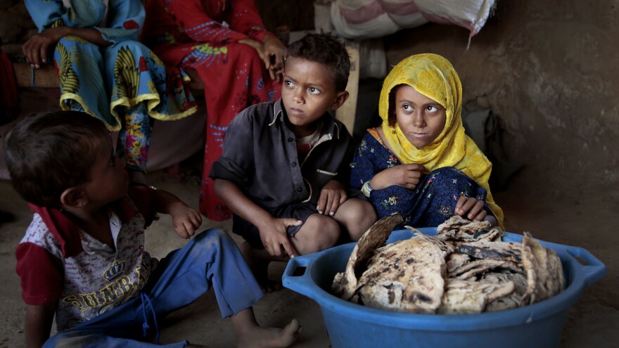 Children sit in front of a tub of moldy bread in their shelter in Aslam, Hajjah, Yemen, last month. The U.N. has estimated that up to 14 million Yemenis — about half the country's population — will suffer severe food shortages in the next few months.