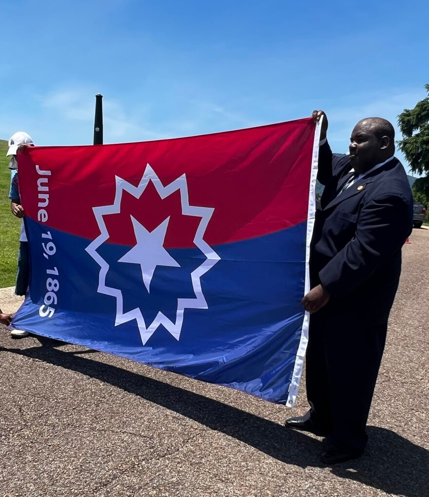 Eric Atkins, at right, holding the Juneteenth flag.