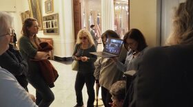 Members of the conservation advocacy group Voices of Wildlife in New Hampshire watch a live stream of a packed hearing on House Bill 1603 from a hallway in the State House Tuesday, March 10