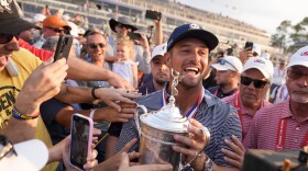 Bryson DeChambeau celebrates with fans and the trophy after winning the U.S. Open golf tournament Sunday, June 16, 2024, in Pinehurst, N.C. (AP Photo/Frank Franklin II)