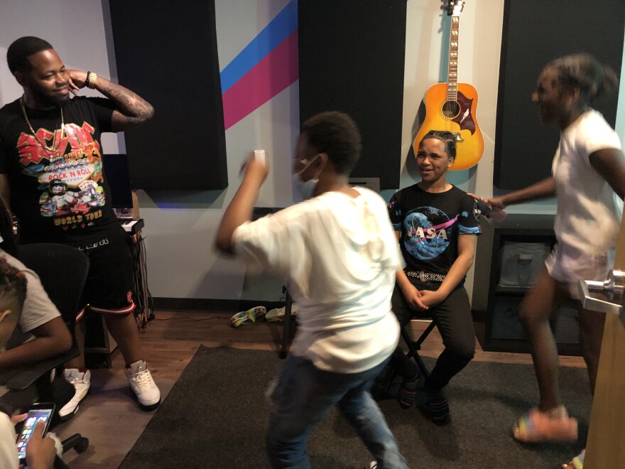 Dae Hill (left) and students react as Byron Moore (middle, white shirt) freestyles.