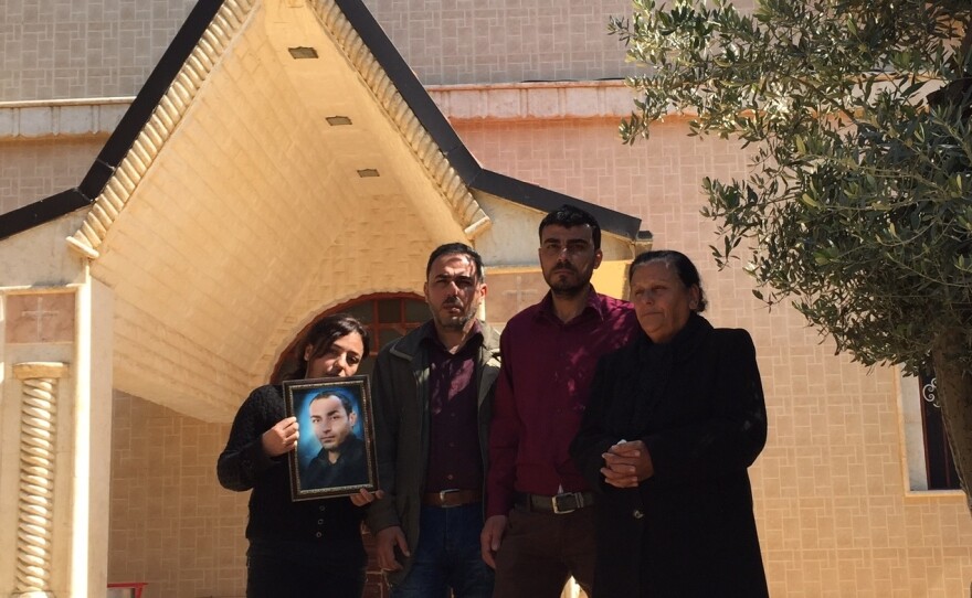 Georgette Melki and her surviving children hold a picture of her son, who was one of at least three people killed after ISIS overran a string of Assyrian Christian villages last year.