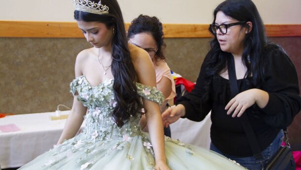 Gabriella Martinez, 14, prepares for the fashion show and is helped by Maritza Leyva and Cristal Ornelas, who stand behind Martinez at the Wenatchee Quinceañera Expo on March 7.