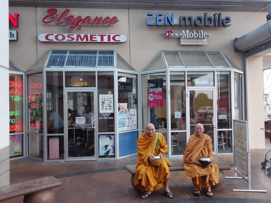 Buddhist monks sit outside a Zen Mobile store in southwest Houston.