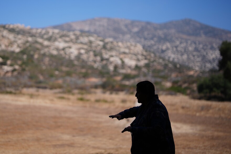 Norma Meza Calles, a Kumeyaay Nation leader, gestures as she speaks of the sacred importance of Kuuchamaa Mountain, behind, at a wellness center, Friday, May 1, 2026, in Tecate, Mexico. (AP Photo/Gregory Bull)