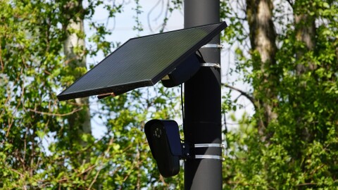 A Flock camera is mounted on a poll to help catch speeders.