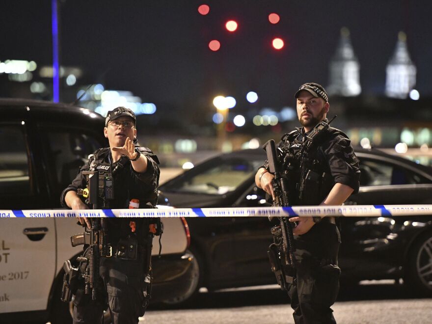 Armed police officers stand guard on London Bridge in central London. British police said they were dealing with "incidents" on London Bridge and nearby Borough Market in the heart of the British capital Saturday.