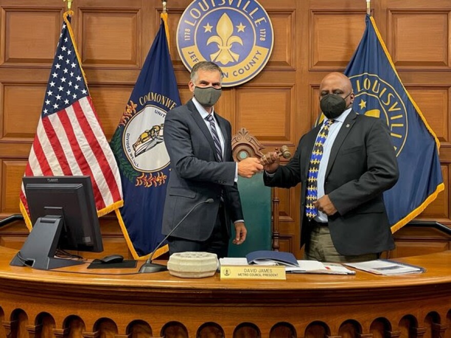 Newly re-elected Metro Council Democratic Caucus Chair Markus Winkler hands the gavel to President David James following Thursday night's vote.