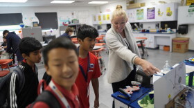 Middle school science teacher Vanessa Stevenson, right, talks with students in her Science Fair class at A.D. Henderson School in Boca Raton, Fla., Tuesday, April 16, 2024. When teachers at the K-8 public school, one of the top-performing schools in Florida, are asked how they succeed, one answer is universal: They have autonomy. (AP Photo/Rebecca Blackwell)