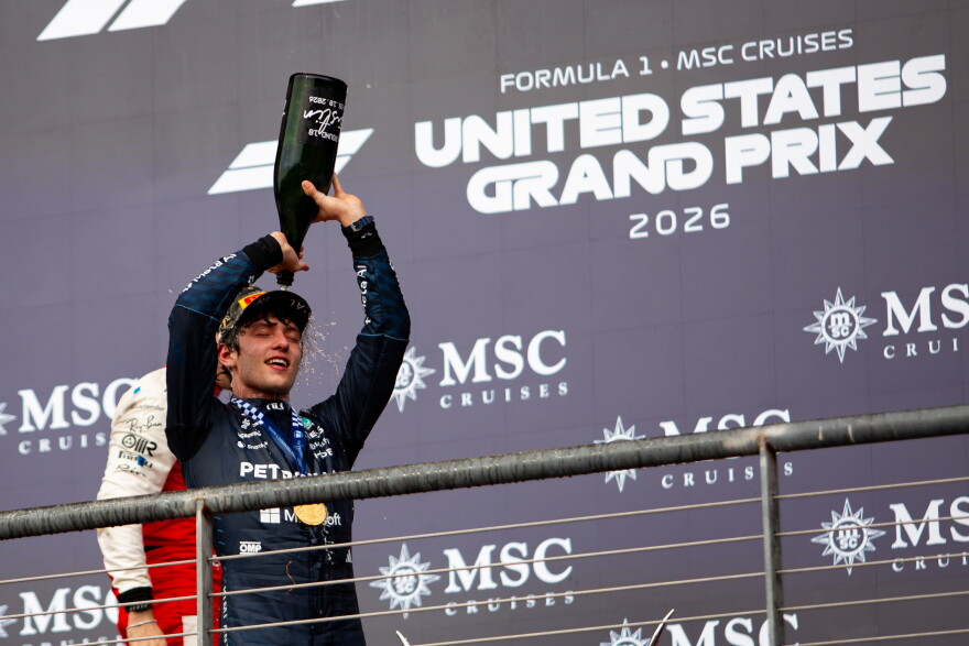 Andrea Kimi Antonelli, 20, pours a non-alcoholic drink over his head in celebration on the podium.