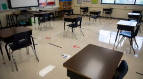 An empty classroom with arrows on the floor directing the flow of student traffic.