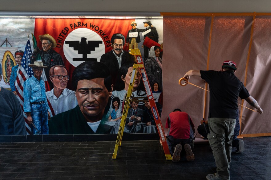 FILE - Workers cover a mural by Emigdio Vasquez featuring Cesar Chavez and other figures at Santa Ana College in Santa Ana, Calif., Thursday, March 19, 2026. (AP Photo/Jae C. Hong,File)