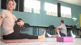 Yoga teacher Liz Getman (left) leads a class on Nov. 29 at GRACE Marketplace. The Gainesville homeless center has been offering the classes since August in an effort to bring the meditative exercise to the disenfranchised, Getman said. (Alexa Lorenzo/WUFT News)