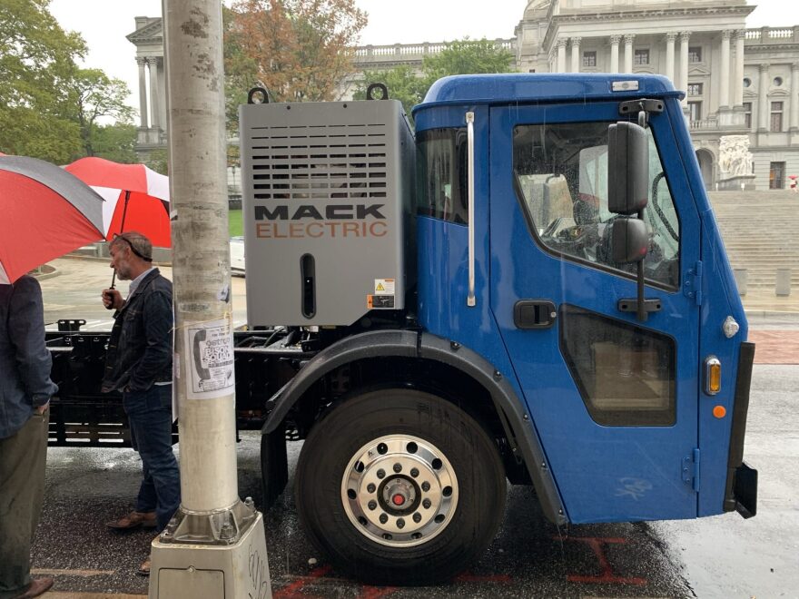 A Mack LR Electric refuse truck parked outside the state capitol.