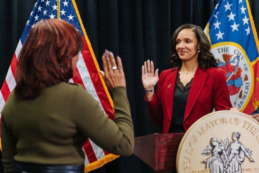 Mayor Mary Sheffield raises her right arm while taking an oath promising to uphold the law and faithfully perform the duties of the position. Across from her is Detroit City Clerk Janice M. Winfrey.