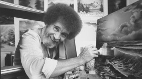 FILE: TV painting instructor and artist Bob Ross using a large paint brush to touch up one of his large seascapes in his studio at home.