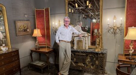 Antique store owner Michael Millard-Lowe stands around furniture inside his Norfolk showroom.
