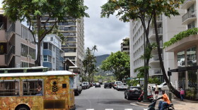 A bus and motorcycle drive down a street in Waikīkī on Oʻahu on July 21, 2026.