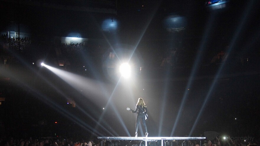 madonna on stage illuminated by spotlights